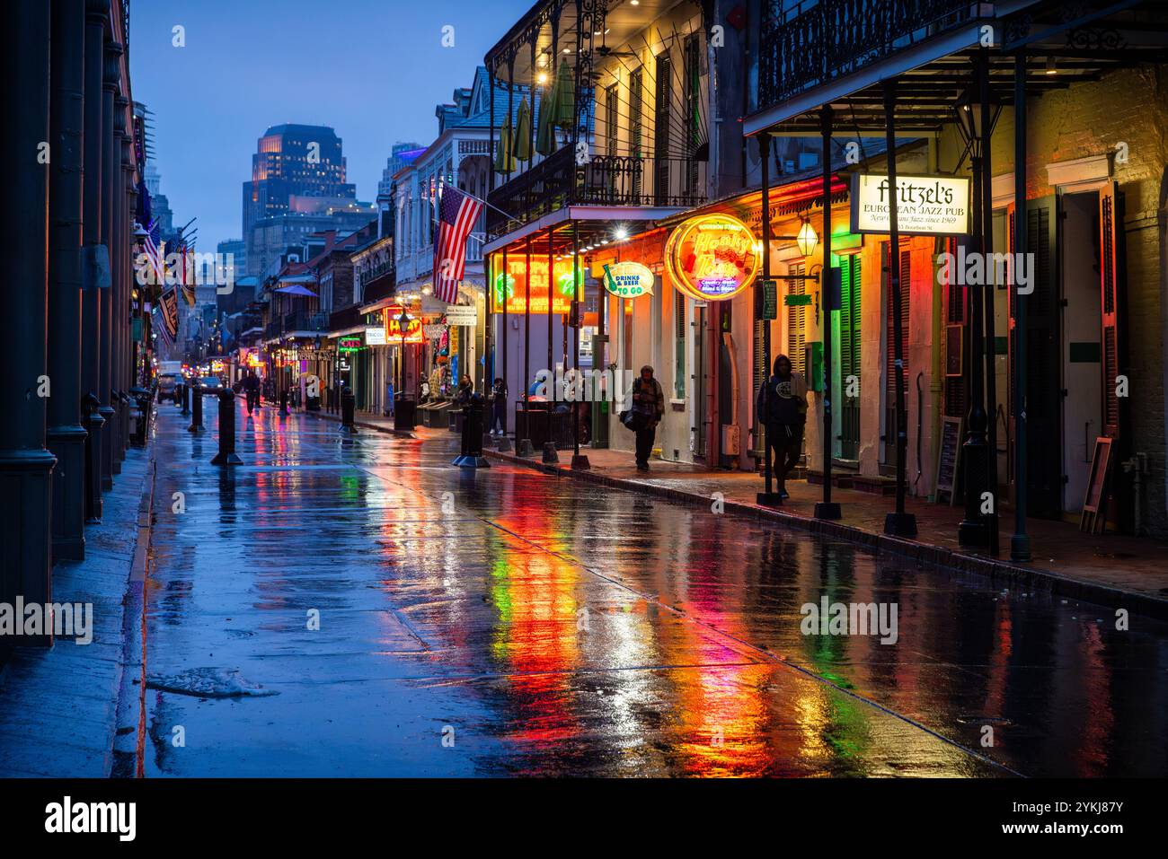 Bourbon Street la nuit avec pluie montrant les signes colorés sur le bloc. Banque D'Images