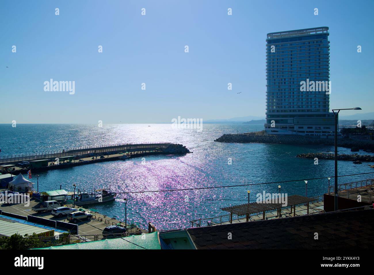 Sokcho, Corée du Sud - 3 novembre 2024 : une vue imprenable sur le port d'Oeongchi et ses eaux scintillantes avec l'hôtel moderne Cassia Sokcho debout Banque D'Images