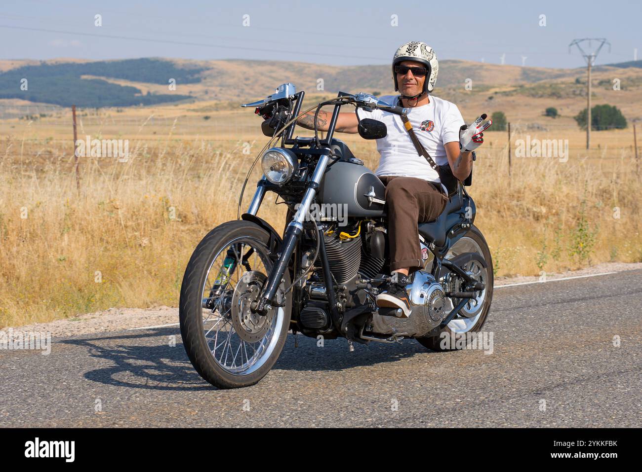 Salutations d'un motard dans une Harley-Davidson. Banque D'Images
