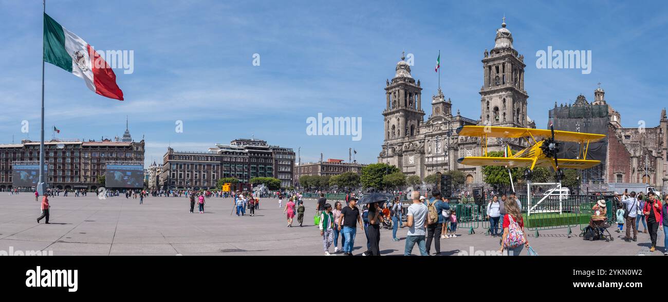 Zócalo Plaza, avec la Cathédrale métropolitaine, le drapeau mexicain et une exposition biplan jaune, commémorant les célébrations du jour de la Révolution. Banque D'Images