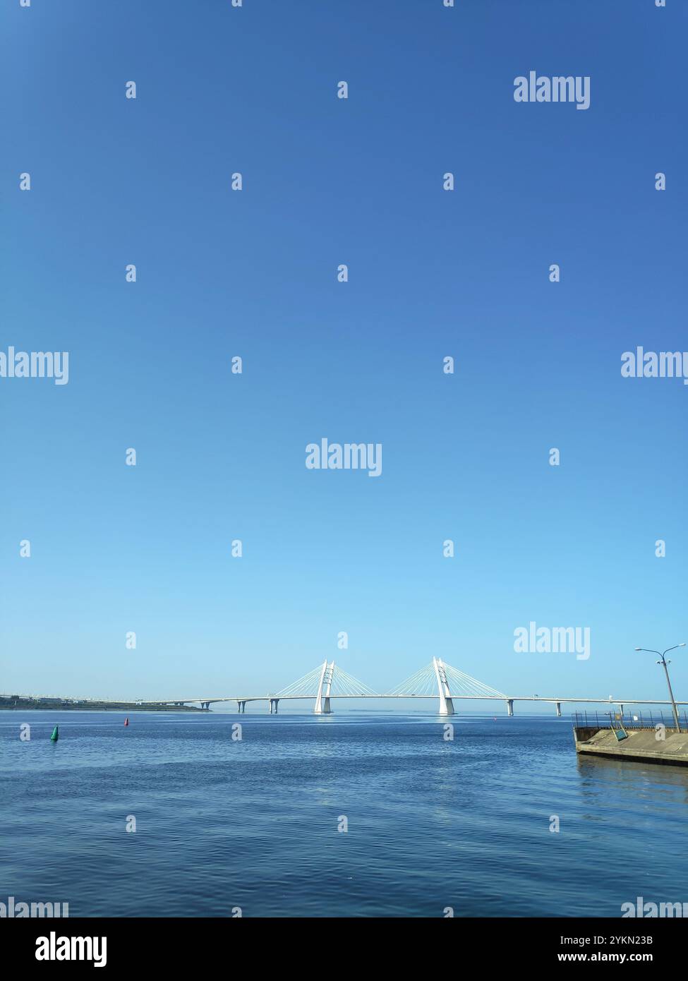 Pont enjambe un plan d'eau, avec un ciel bleu clair au-dessus. Le pont est blanc et l'eau est calme Banque D'Images