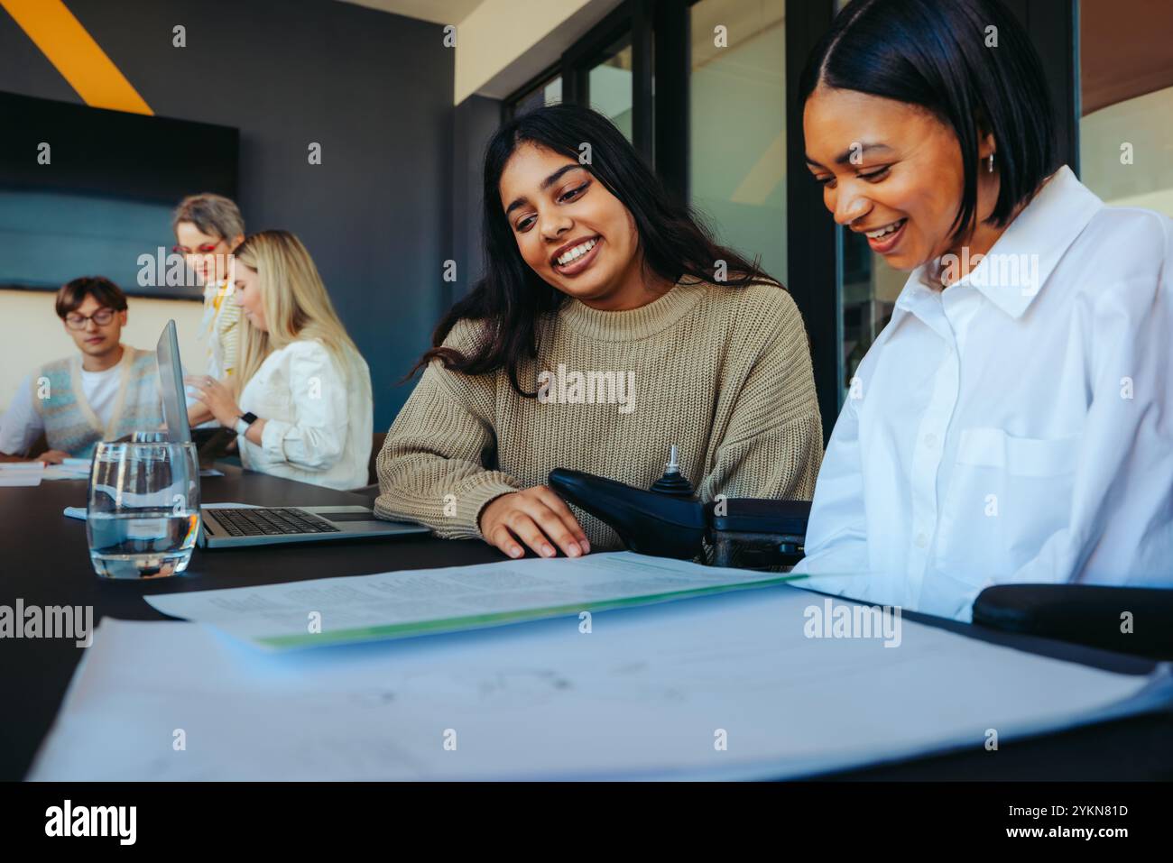 Les étudiants de premier cycle dans une salle de classe collaborent à un projet collégial, mettant en valeur le travail d'équipe et les perspectives diverses dans un environnement éducatif moderne. Banque D'Images