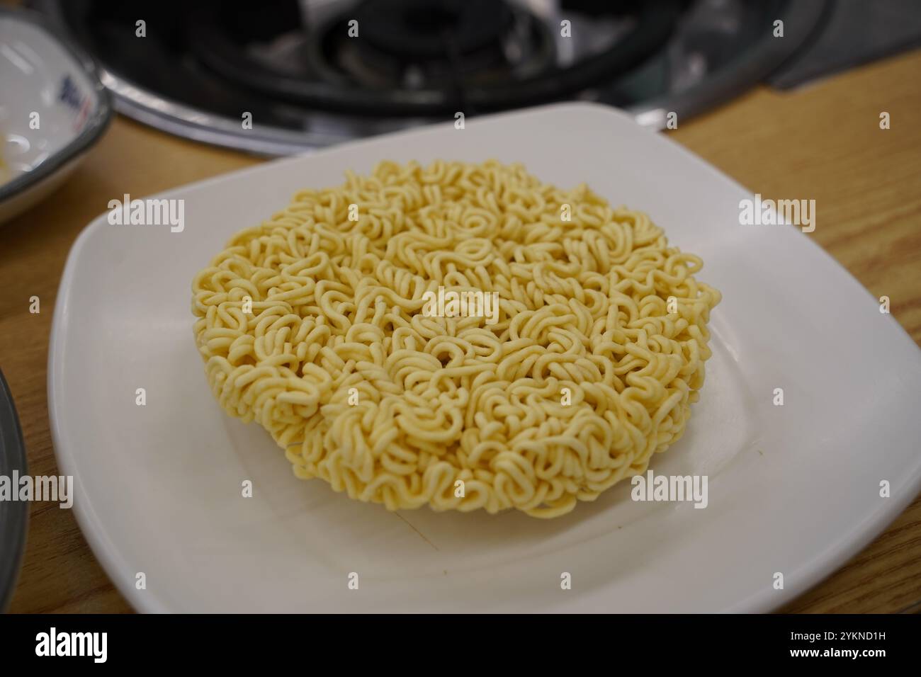 Nouilles instantanées dans une assiette blanche sur une table en bois Banque D'Images