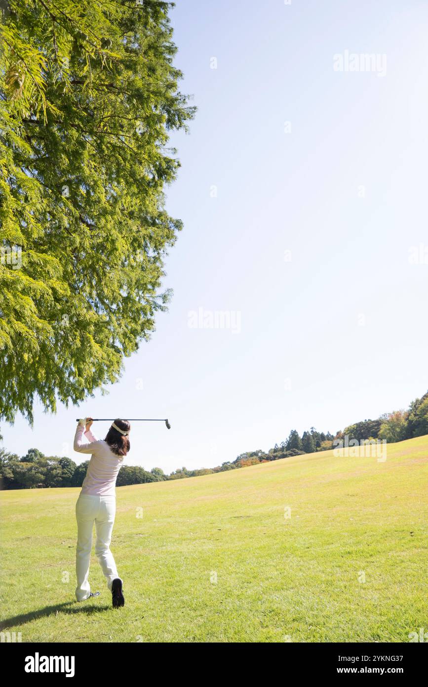Femme d'âge moyen jouant au golf Banque D'Images