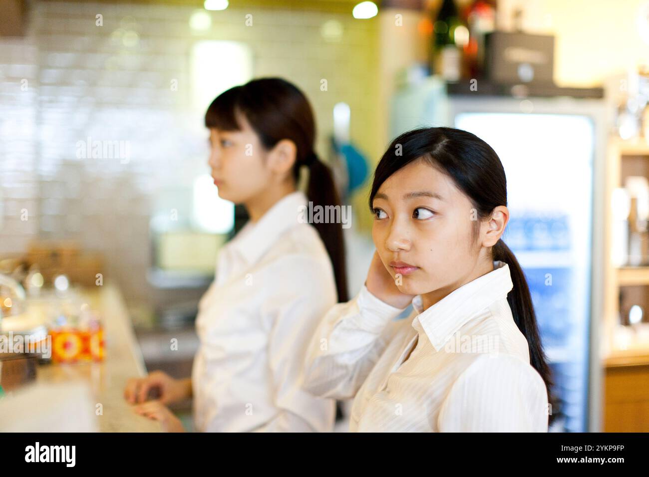 Deux femmes avec des chemises blanches et les cheveux attachés Banque D'Images