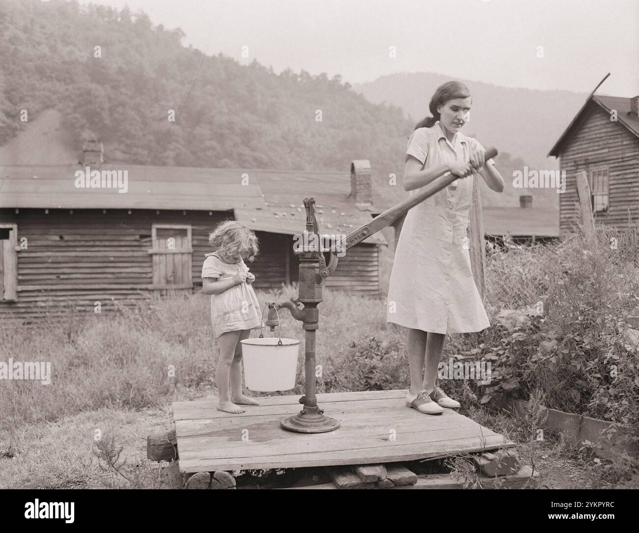 Photo vintage de la fille et de la femme du mineur. Bobbie Jean Sergent, 4 ans, va avec Lucy, 26 ans, qui est aveugle, pour obtenir de l'eau. P V & K Coal Company, Clover Gap mine, Lejunior, comté de Harlan, Kentucky. ÉTATS-UNIS. Septembre 1946 Banque D'Images