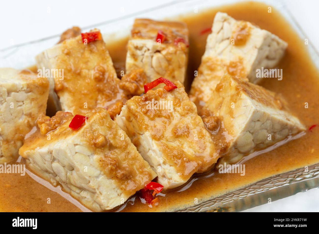 Tempeh ou tempe mariné dans une sauce aux cacahuètes et Chili. Banque D'Images