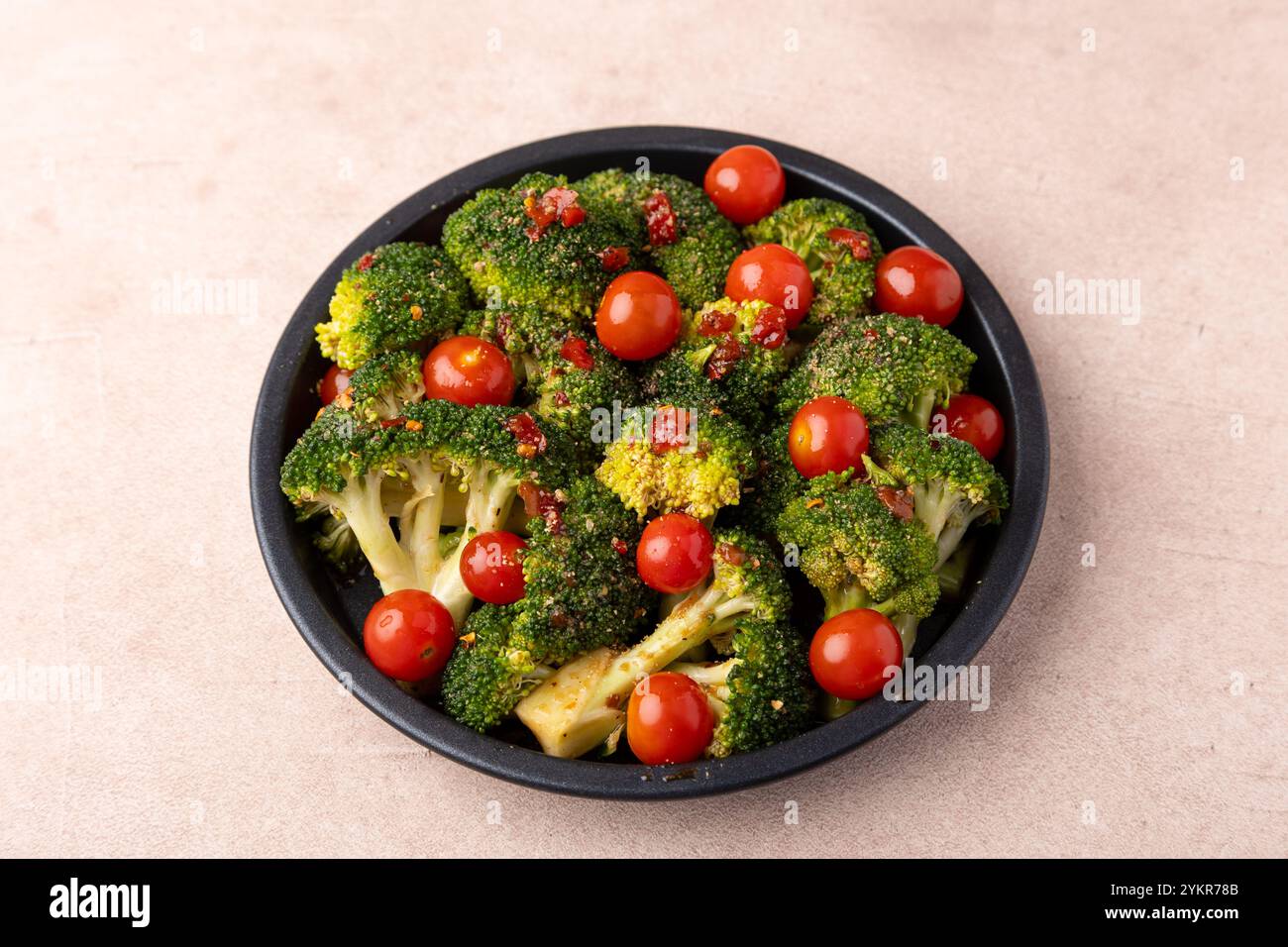 Chou brocoli mariné dans une sauce épicée-sucrée et épices avec tomates cerises. Préparation pour la cuisson. Cuisine maison saine. Mise au point sélective, gros plan Banque D'Images
