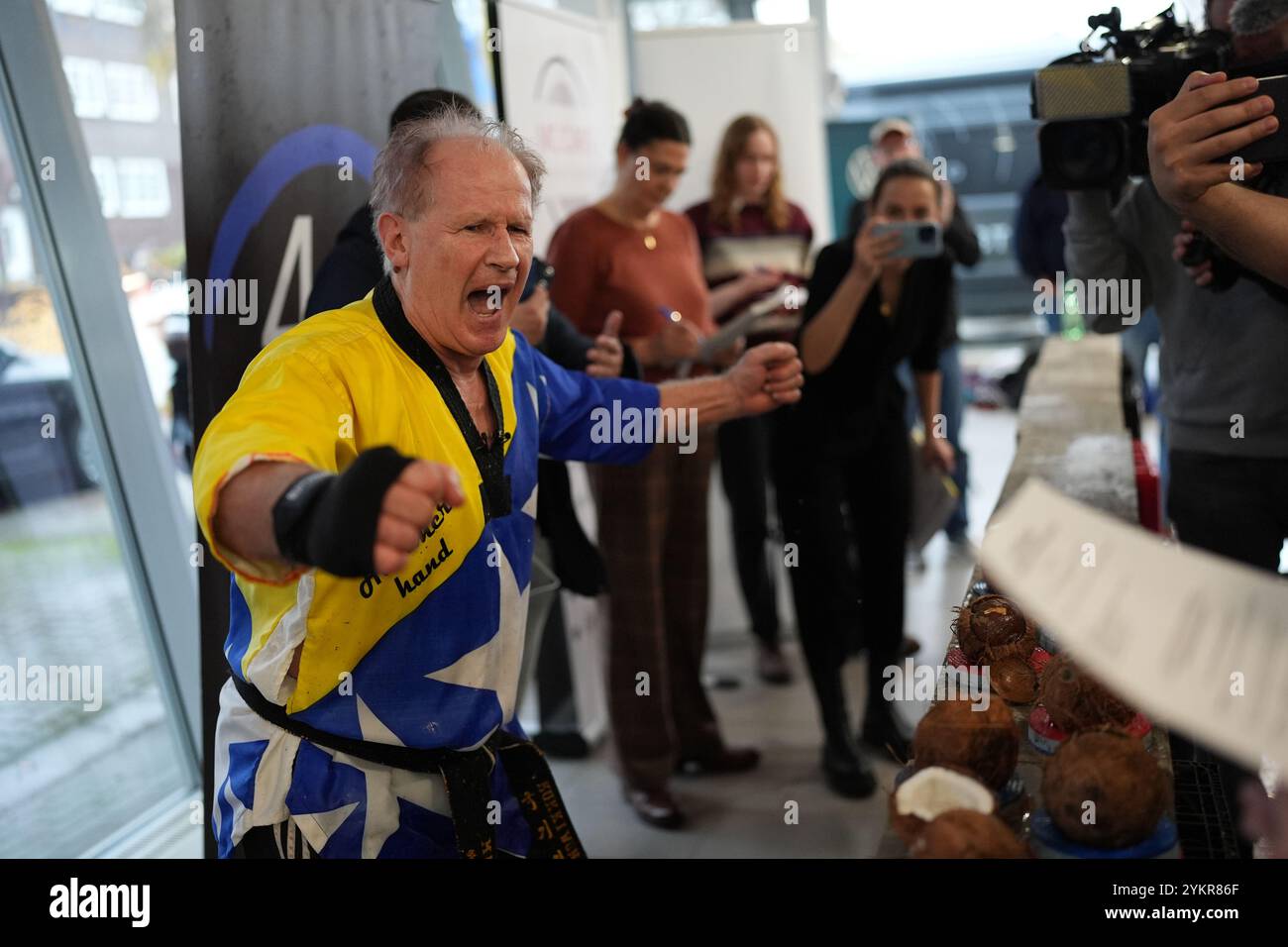 Hambourg, Allemagne. 19 novembre 2024. Muhamed 'Hammerhand' Kahrimanovic célèbre après avoir battu le record du monde pour briser des noix de coco avec sa main à l'Elbtor dans la branche Hambourg Altona VW. Les tentatives de record ont lieu dans le cadre de la soixante-dixième Journée mondiale du record Guinness. Crédit : Marcus Brandt/dpa/Alamy Live News Banque D'Images