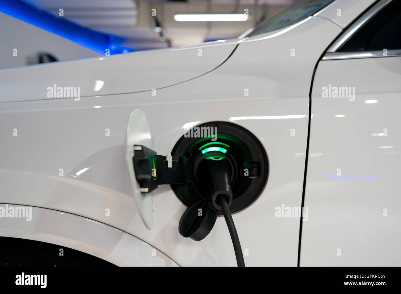 Parking pour véhicule électrique ou véhicule électrique à la station de charge et câble d'alimentation branché. Chargez l'alimentation de la batterie du véhicule électrique ou hybride. Énergie verte et éco Banque D'Images