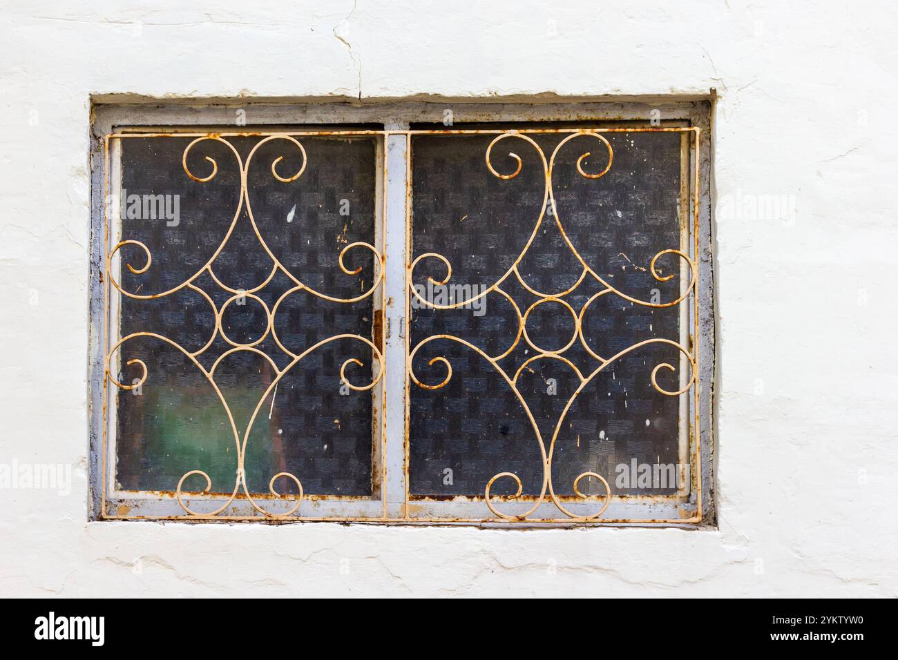 Grille de fer antique sur fenêtre rustique avec design décoratif Banque D'Images