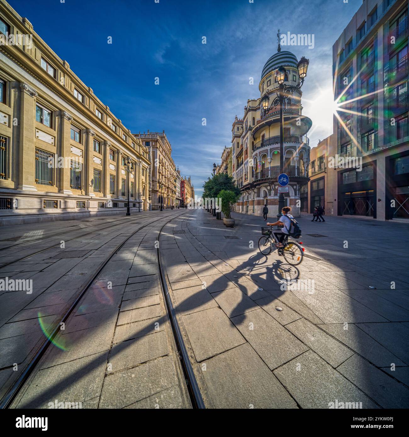 Séville, Espagne, janvier 28 2021, Un cycliste passe devant le pittoresque bâtiment Adriatica sur l'Avenida de la Constitucion à Séville. La rue est bordée d'esprit Banque D'Images