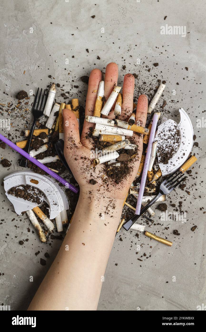 Main tenant pile de cigarettes avec de la saleté. Concept de pollution de  l'environnement Photo Stock