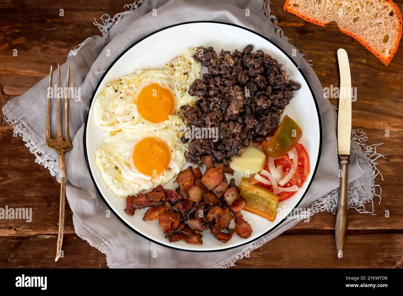 Cuisine traditionnelle brésilienne de tous les jours, ragoût de haricots noirs, bacon, œuf, salade, cornichons. De la vraie nourriture rustique Banque D'Images