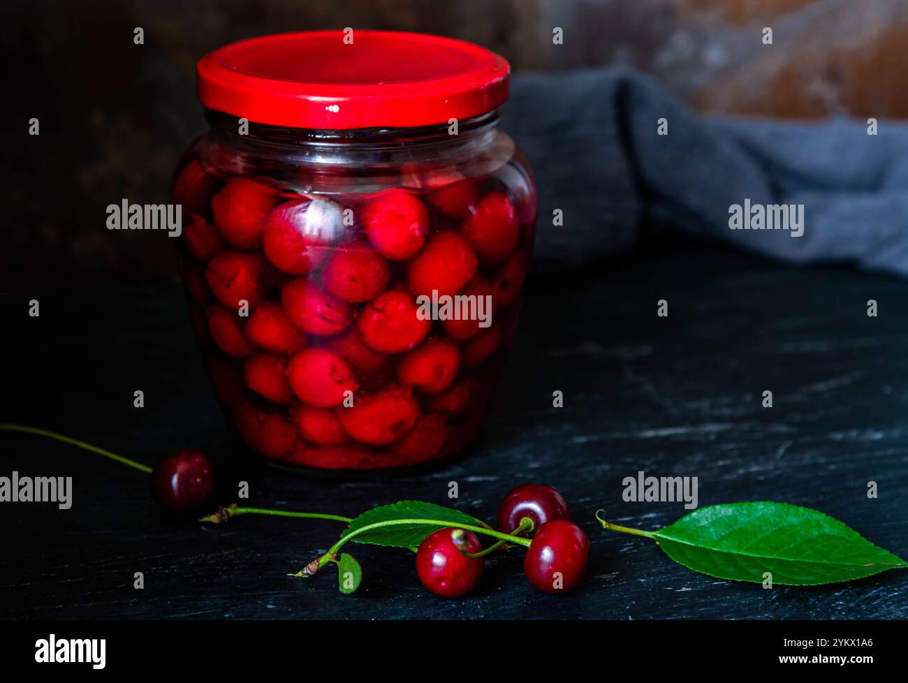 Conserves de cerises faites maison. Cerises fraîches dénoyautées dans du sirop de sucre dans un bocal en verre. Nourriture biologique en conserve du jardin. Banque D'Images