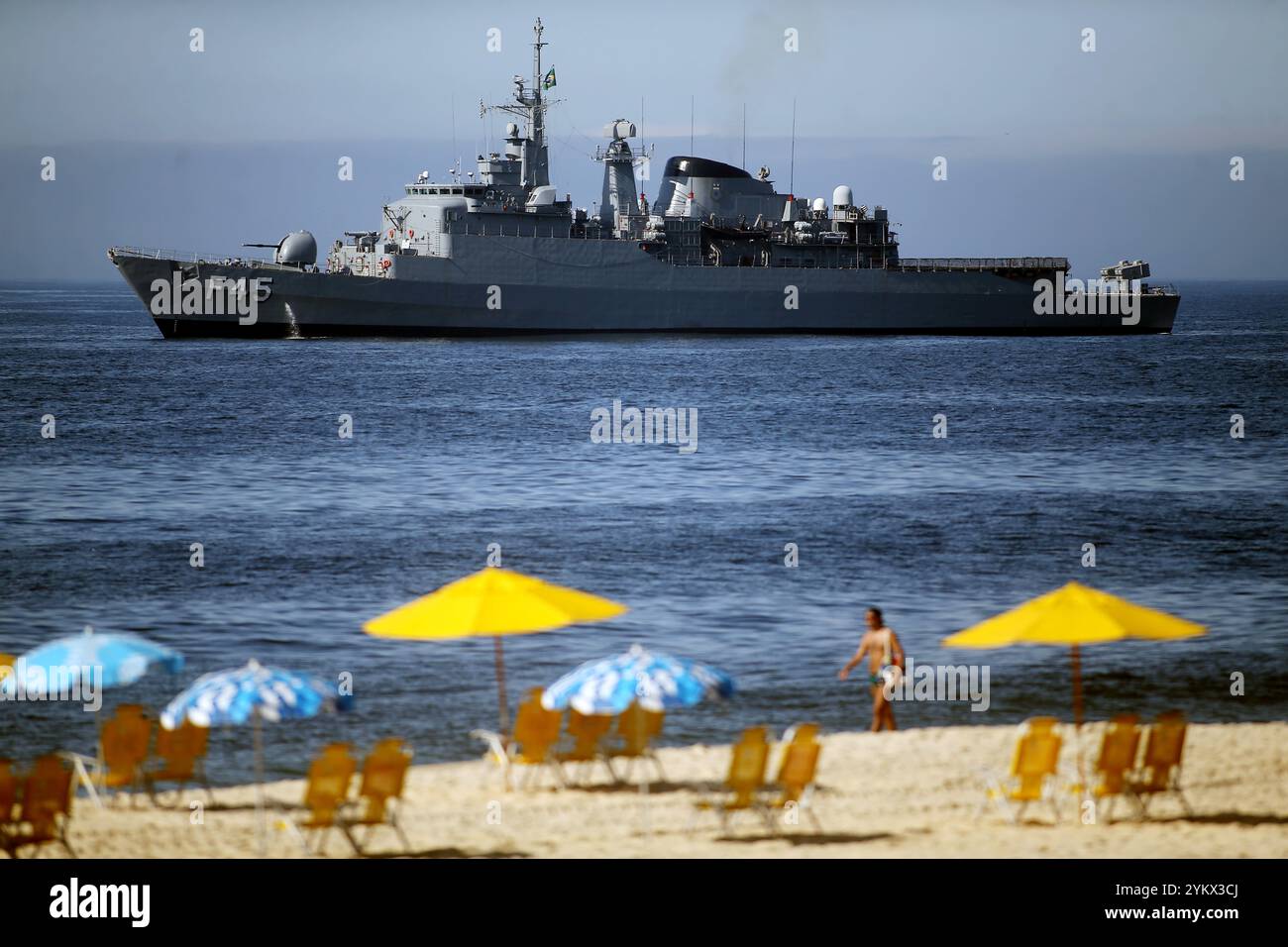 19 novembre 2024, Rio de Janeiro, Rio de Janeiro, Brésil : la vie continue comme d'habitude sur la plage d'Ipanema, avec la frégate de la marine brésilienne UniÃ£o (F-45) stationnée juste au large. Rio de Janeiro est sous forte présence policière et militaire le deuxième jour du Sommet du G20 de 2024, alors que les dirigeants mondiaux se réunissent du 18 au 19 novembre. C'est la première fois que le Brésil accueille ce sommet, où les chefs d'État aborderont des questions mondiales cruciales. Le G20, qui représente 85% du PIB mondial et les deux tiers de la population mondiale, est protégé par des mesures de sécurité strictes tout au long de l'événement. (Crédit image : © Banque D'Images