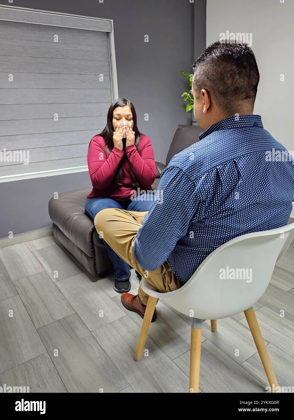 Psychologue masculin à la peau foncée donne une thérapie à une femme adulte latine écoutant le travail de santé mentale de son patient pour l'anxiété et la dépression Banque D'Images