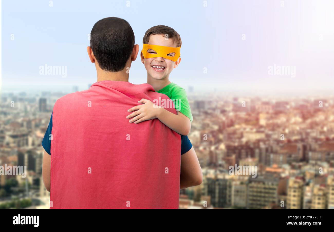 Père heureux et affectueux. Papa et son fils jouent à l'extérieur. Papa et garçon vêtus de super héros. Concept de fête des pères. Banque D'Images