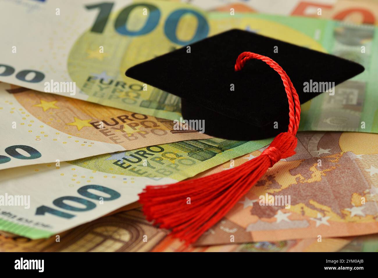 Chapeau de graduation sur les billets en euros - concept de bourse et d'argent pour l'enseignement collégial Banque D'Images
