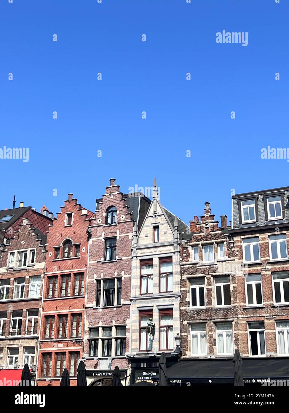 Découvrez le charme de l'architecture belge sous un ciel bleu parfait. L'héritage rencontre la beauté dans les moindres détails. 🌟 - Image de stock capturée avec un smartphone