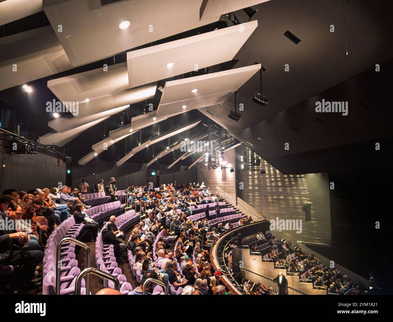 Auditorium du National Theater de Londres, Royaume-Uni avec public assis sur des rangées étagées en attente de représentation. Banque D'Images