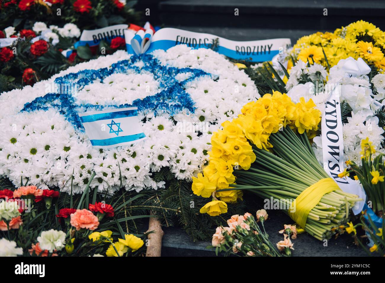 Drapeau israélien et jonquilles jaunes sur des marches de pierre, symbolisant le souvenir de l'Holocauste et le deuil national Banque D'Images