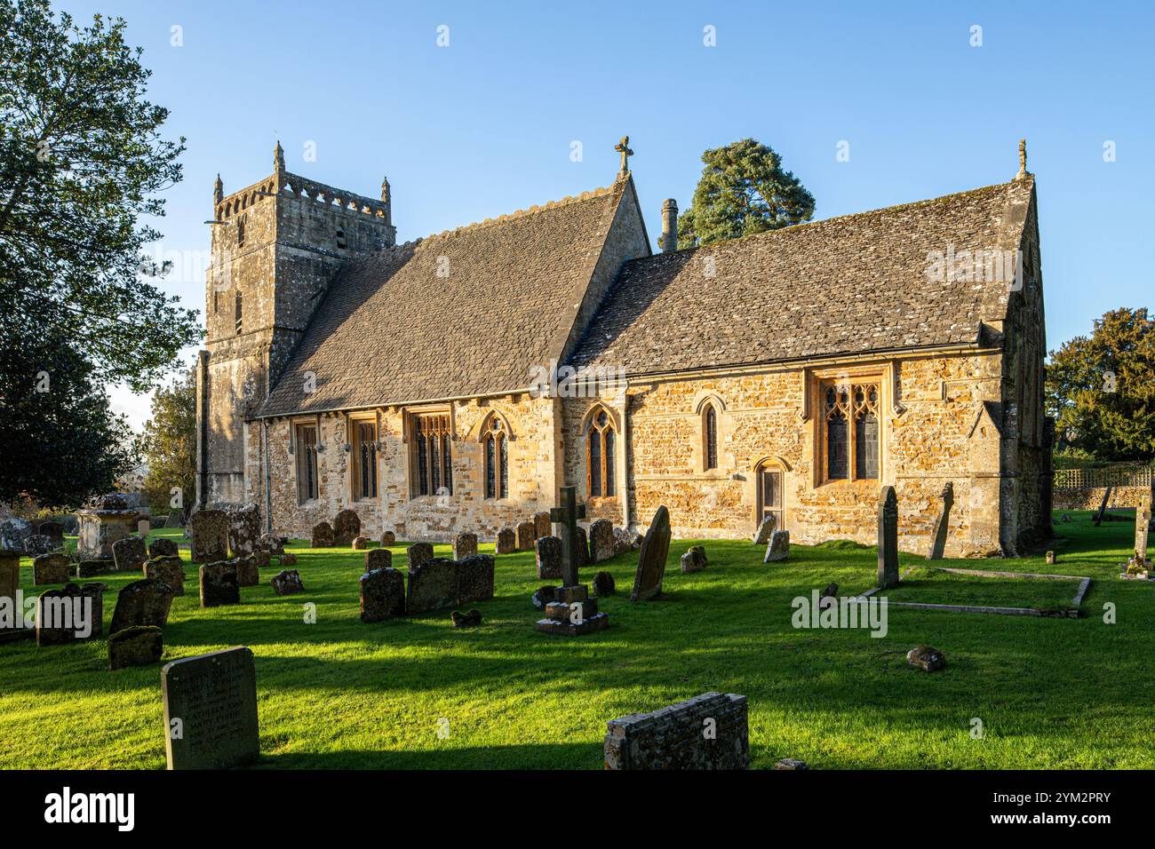 Lumière du soir sur l'église St Laurence du 12ème siècle dans le village Cotswold de Wyck Rissington, Gloucestershire, Angleterre Royaume-Uni Banque D'Images