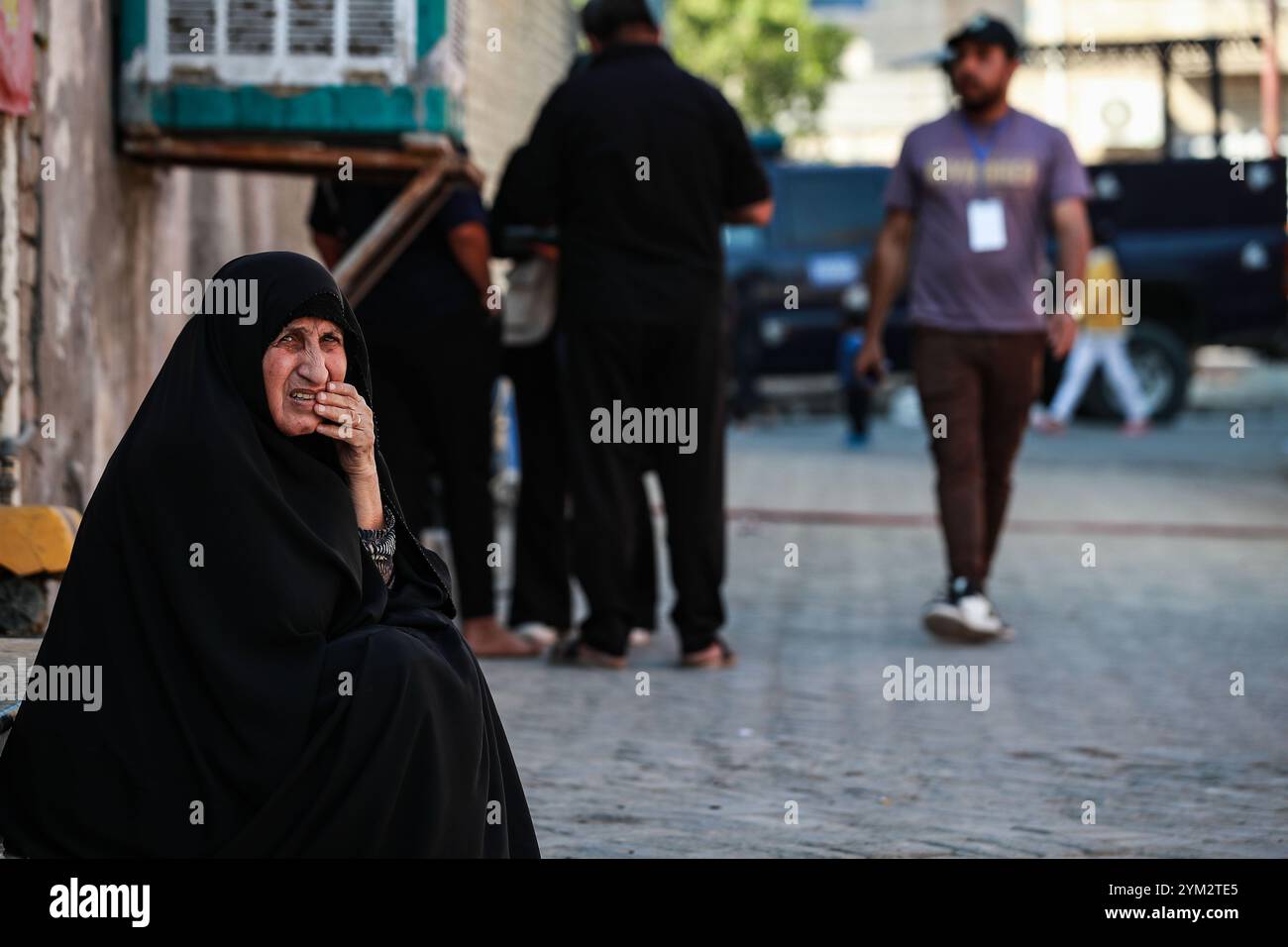 Bagdad, Irak. 20 novembre 2024. Une femme irakienne âgée est assise dans la rue pendant le premier jour du recensement national irakien dans la ville de Sadr à Bagdad. L'Iraq procède à son premier recensement de la population à l'échelle nationale en 37 ans, une mesure qui devrait avoir un impact sur la répartition des ressources, ce qui a ravivé les tensions entre Bagdad et la région semi-autonome du Kurdistan, craignant qu'un déclin de la population kurde ne réduise leur influence politique et leurs droits économiques. Crédit : Ameer Al-Mohammedawi/dpa/Alamy Live News Banque D'Images