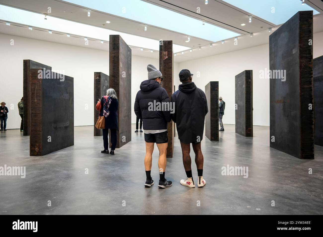 Les visiteurs de la David Zwirner Gallery à Chelsea à New York le samedi 16 novembre 2024 parcourent l’artiste Richard SerraÕs ÒEvery qui WayÓ (2015). Seize panneaux d'acier vieilli affichés dans une grille décalée invitent les amateurs d'art à faire l'expérience de la marche dans les monolithes. (© Richard B. Levine) Banque D'Images