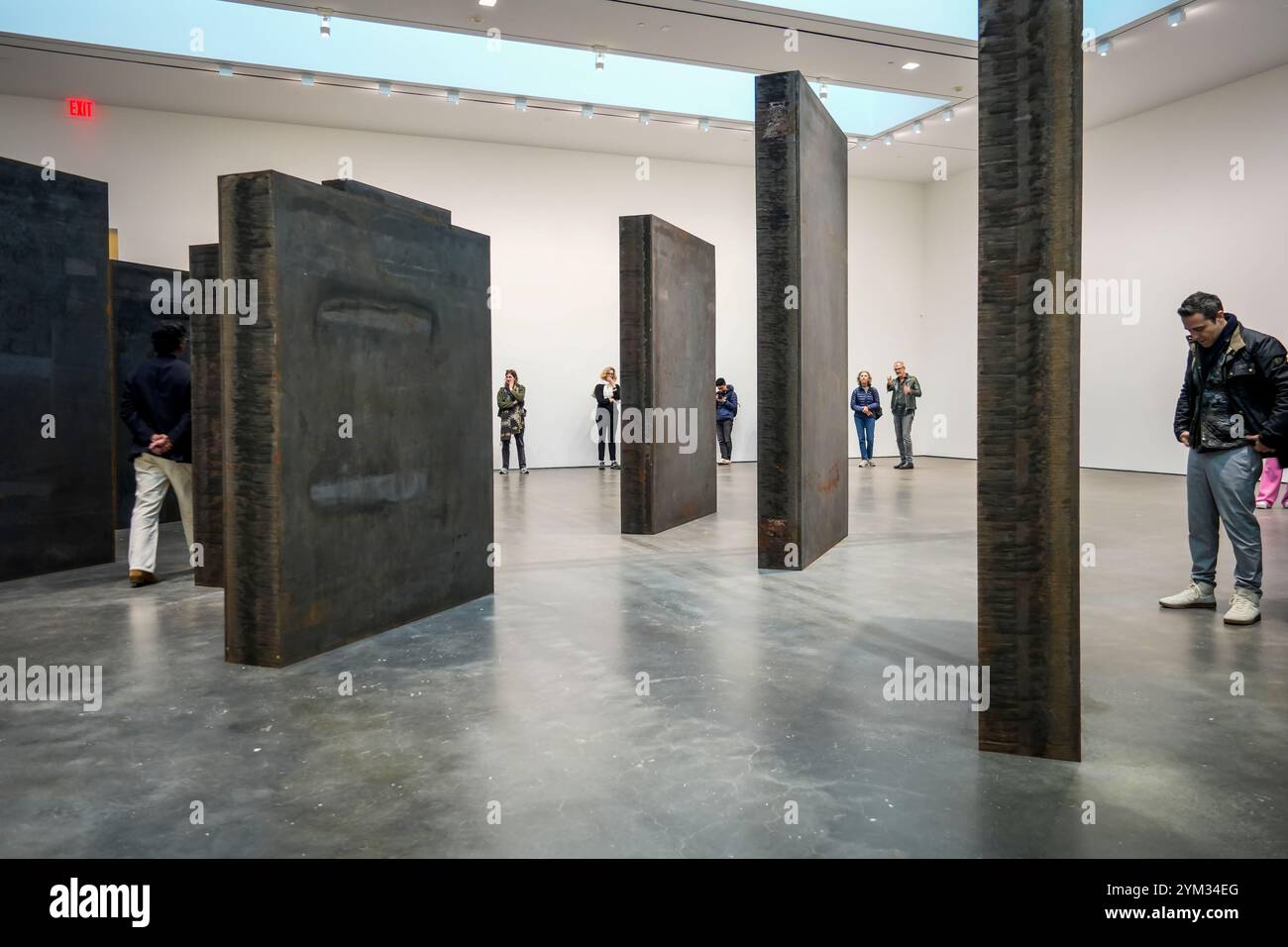 Les visiteurs de la David Zwirner Gallery à Chelsea à New York le samedi 16 novembre 2024 parcourent l’artiste Richard SerraÕs ÒEvery qui WayÓ (2015). Seize panneaux d'acier vieilli affichés dans une grille décalée invitent les amateurs d'art à faire l'expérience de la marche dans les monolithes. (© Richard B. Levine) Banque D'Images