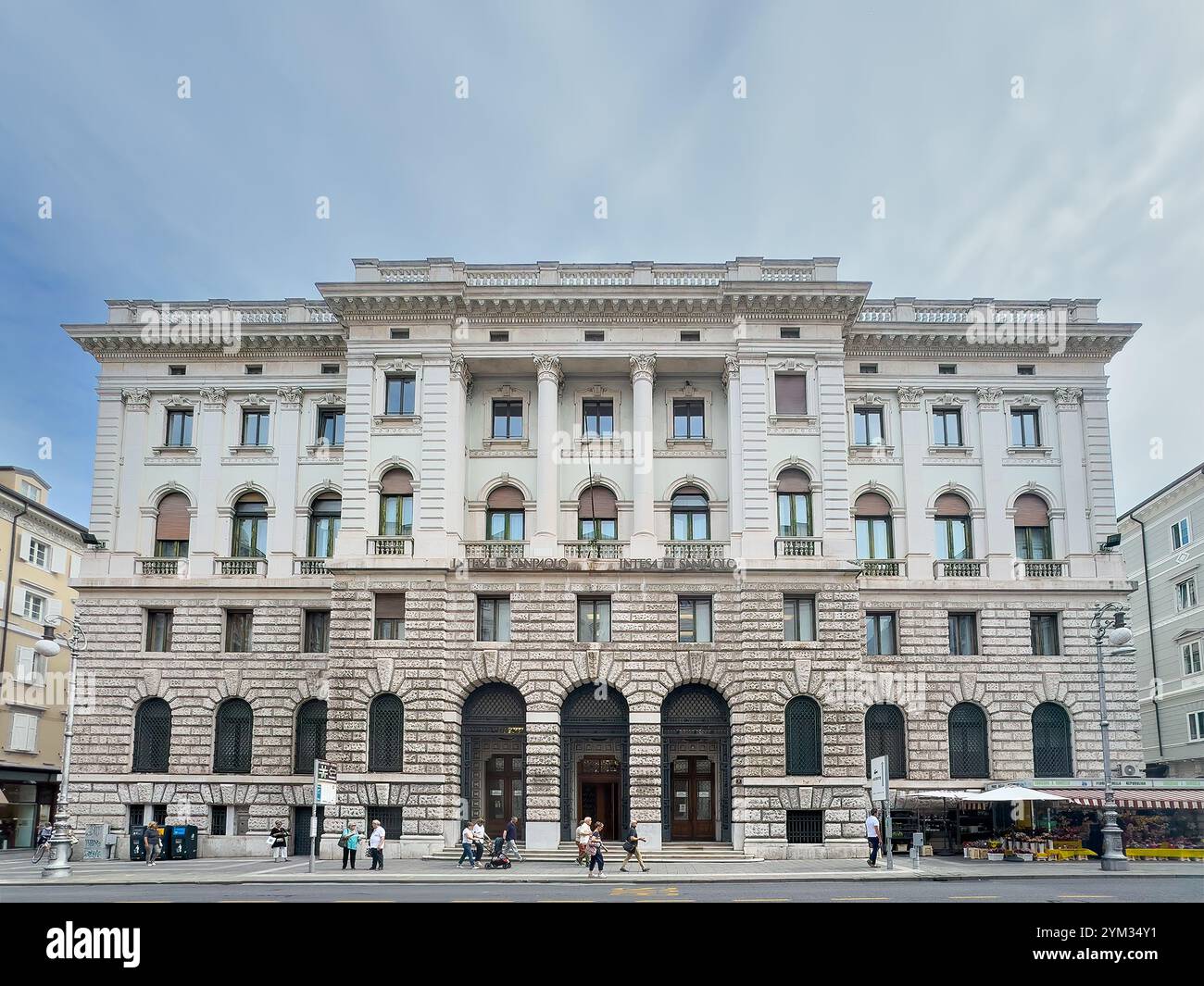 Trieste, Italie - 27 juin 2024 : bâtiment historique monumental blanc Intesa Sanpaolo sur la via Mazzini. Piétons présents Banque D'Images