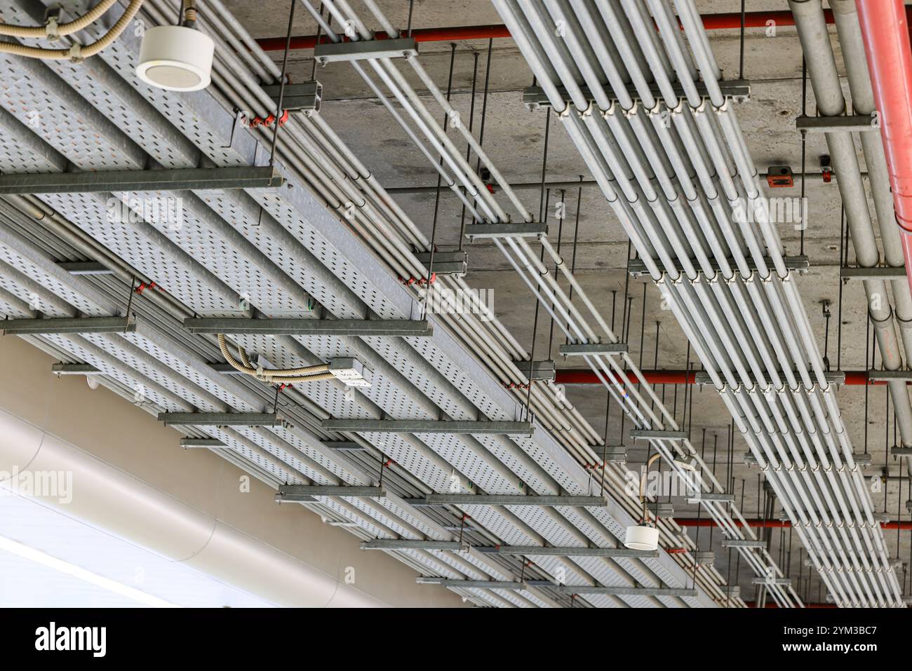 Canalisation en acier électrique, chemin de fil de câble électrique sur le mur, acheminement de câble entre le panneau de distribution électrique avec l'équipement, construction d'industrie Banque D'Images