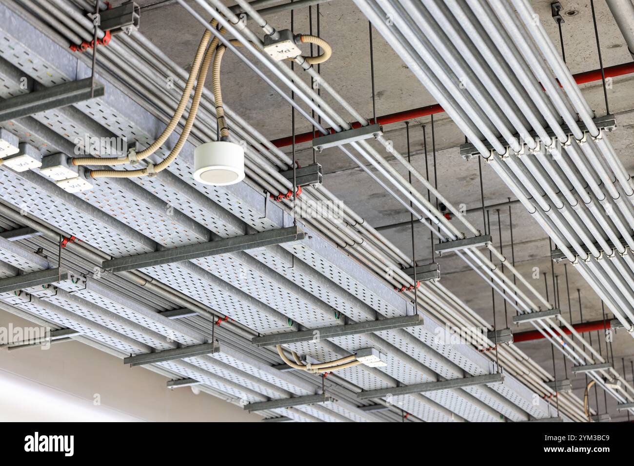 Canalisation en acier électrique, chemin de fil de câble électrique sur le mur, acheminement de câble entre le panneau de distribution électrique avec l'équipement, construction d'industrie Banque D'Images