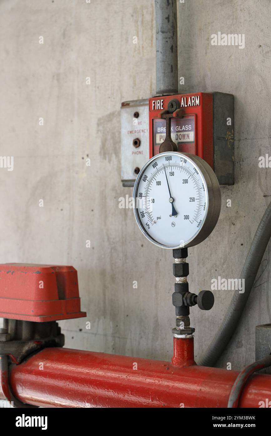 Manomètres ou manomètre de pression montés sur le pipeline et système D'ALARME INCENDIE DE signal, tubes métalliques fixés sur le mur. Banque D'Images