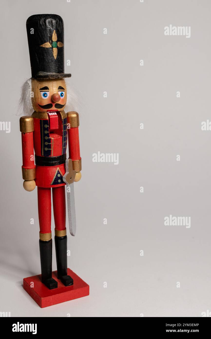 Figurine casse-noix de Noël positionnée sur le côté gauche d'un fond lumineux Banque D'Images
