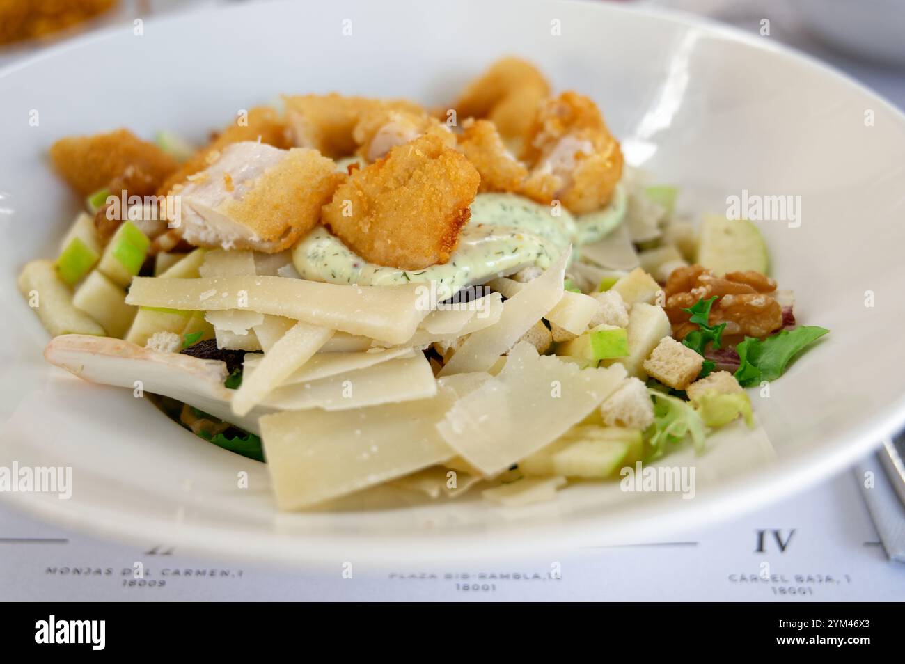 Une salade César dense avec du poulet croustillant, du parmesan rasé et une vinaigrette crémeuse aux herbes Banque D'Images