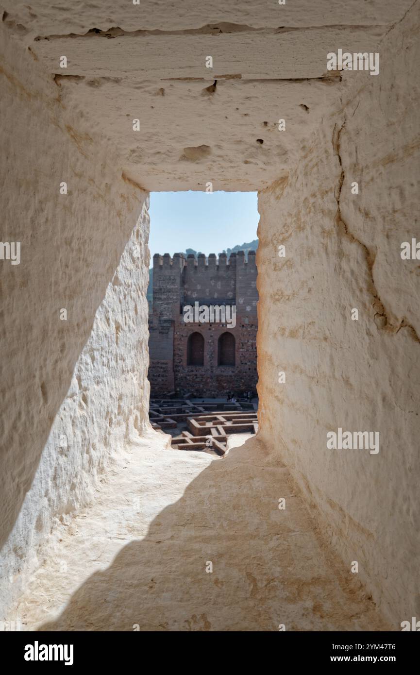 Un coup d’œil à travers un passage en pierre encadre les murs de la forteresse de l’Alhambra Banque D'Images