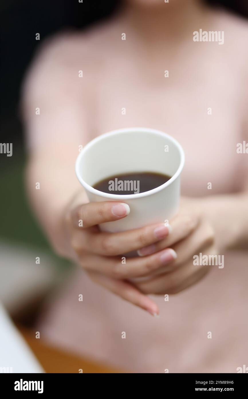 Jeune femme avec tasse de papier de café Banque D'Images