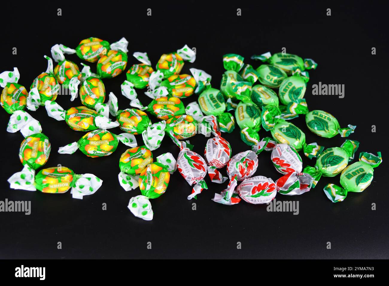 Nourriture, friandises, vacances, fêtes. Beaux bonbons aux fruits fabriqués à partir de jus et d'extrait de fruits emballés dans du polyéthylène coloré et brillant. Banque D'Images