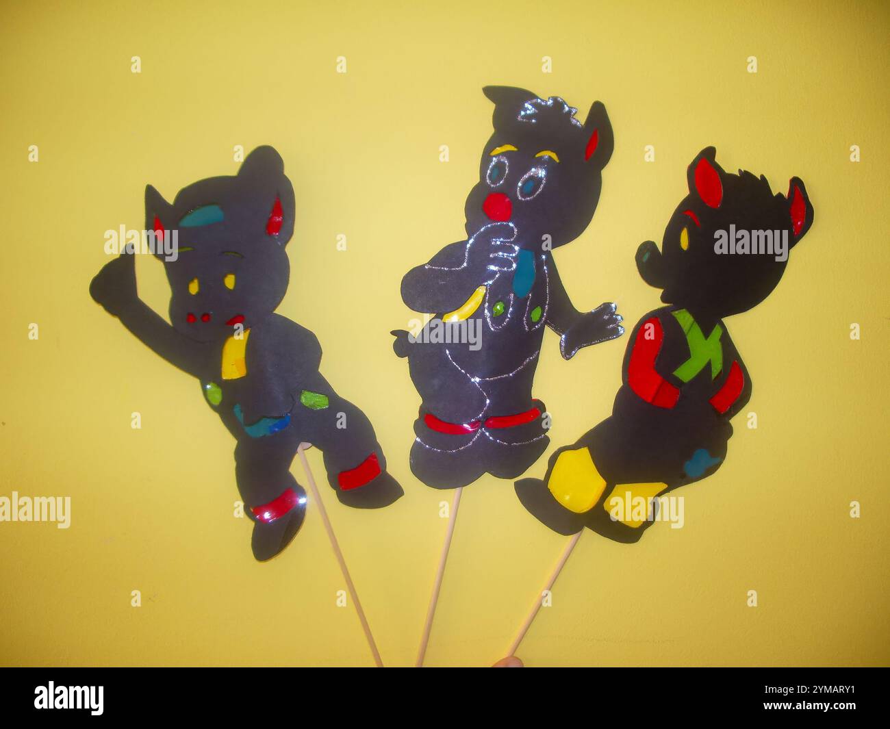 Trois porcs faits à la main en cartam et matériaux transparents, avec un bâton pour tenir et agir. Banque D'Images