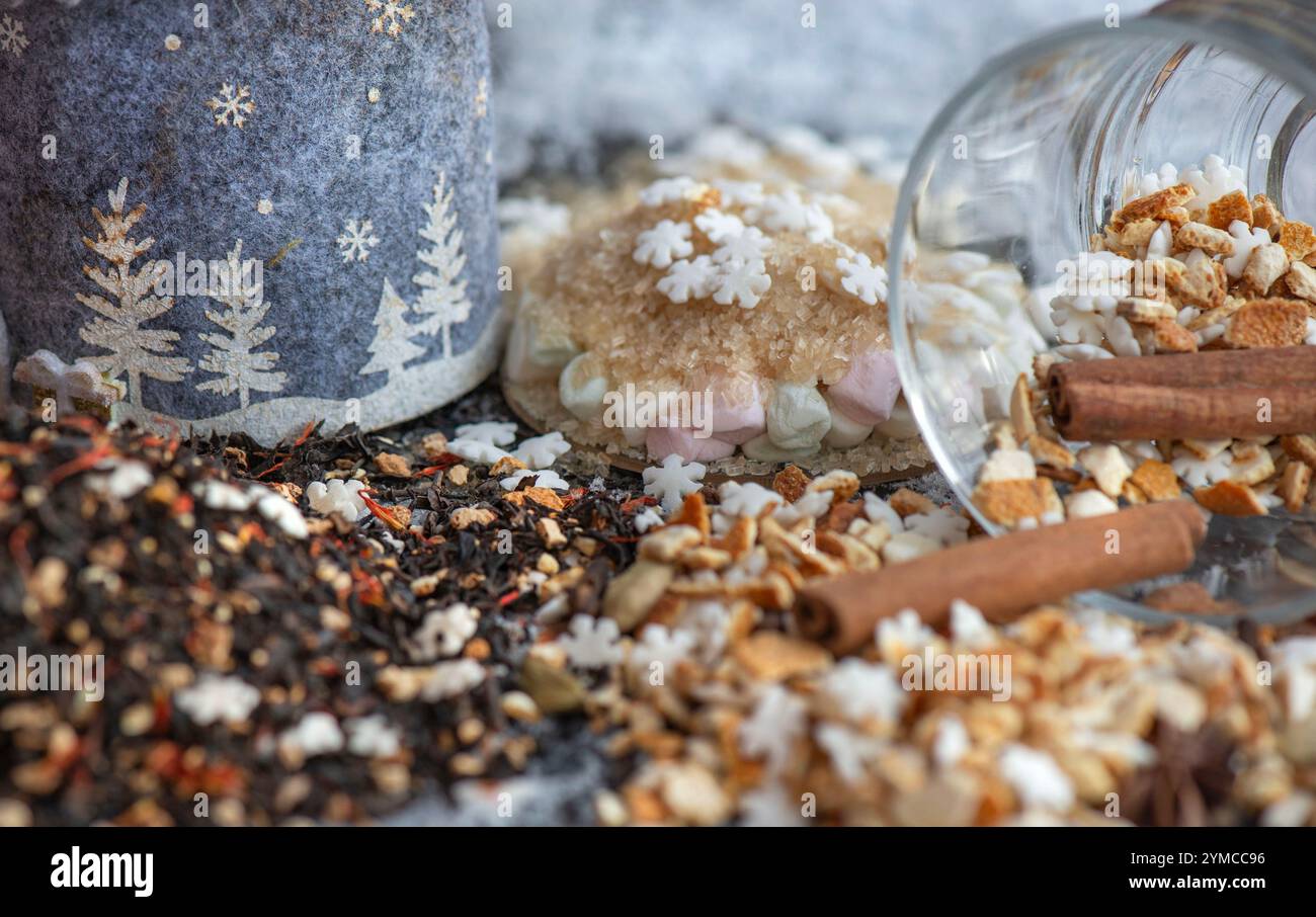 ingrédient de boisson chaude d'hiver renversé avec des épices, en forme d'étoile et de sucre et de tasse de verre retournent sur fond neigeux Banque D'Images