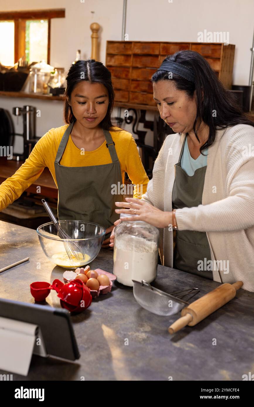 Grand-mère et adolescente asiatique cuisinant ensemble dans la cuisine, préparant des friandises, à la maison Banque D'Images