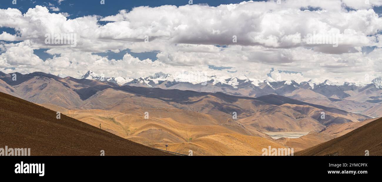 FRIENDLY HIGHWAY, TIBET, CHINE : paysage hivernal jaune sec, drapeaux de prière colorés et chaîne de montagnes enneigées, sur la route de Lhassa aux Népalais Banque D'Images