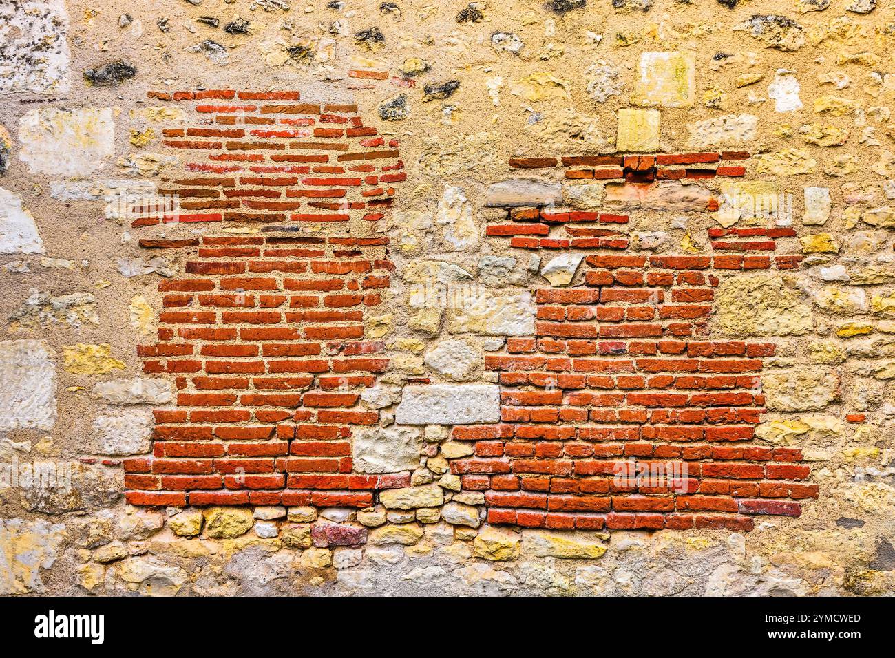 Une ancienne réparation ou reconstruction d'un mur de pierre avec des briques rouges - angles-sur-l'Anglin, Vienne (86), France. Banque D'Images