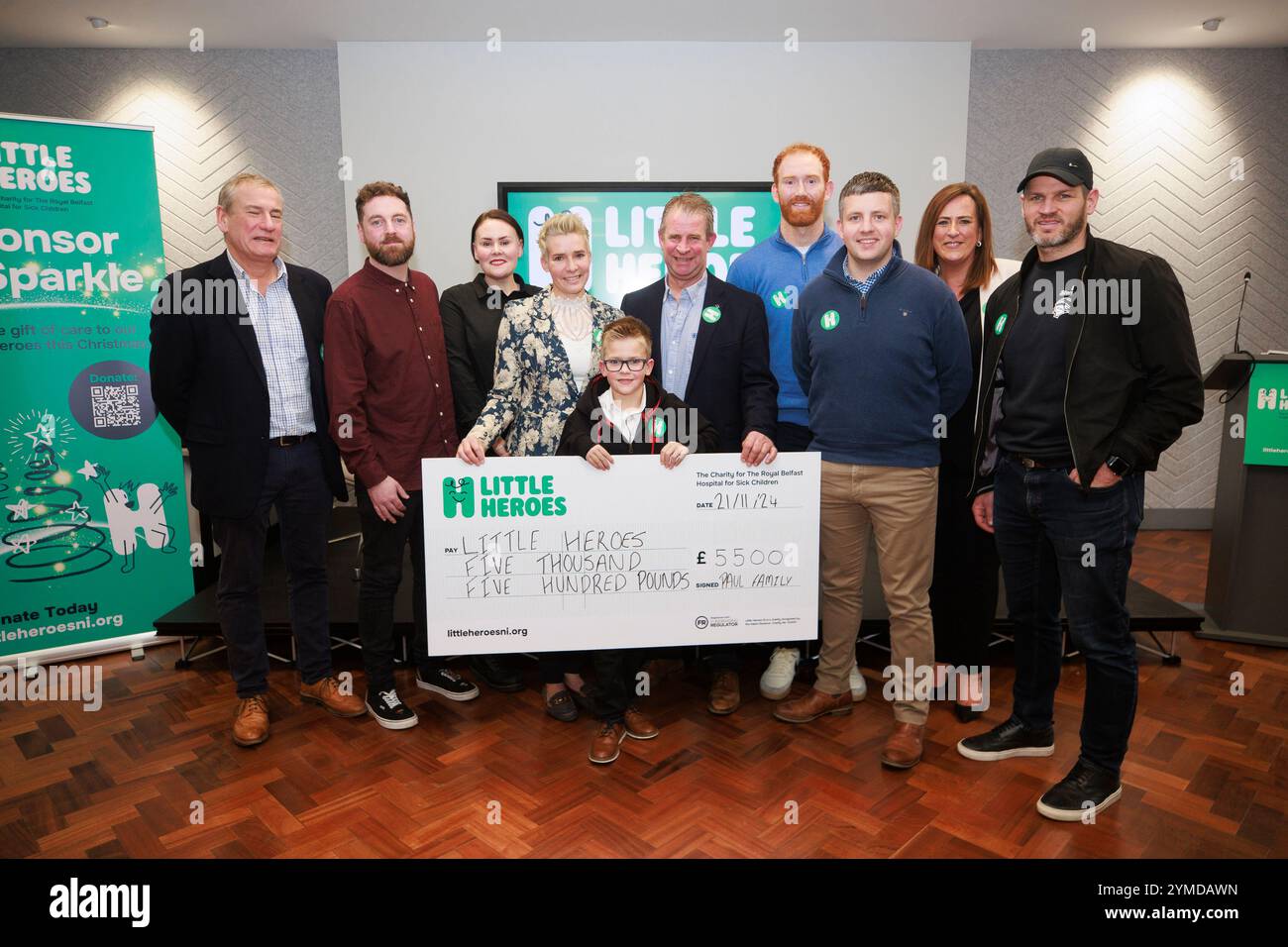 (De gauche à droite) L'ambassadeur Mark Huffam, Ryan et Nadine Chambers, Leanne, Cody et Alan Paul, l'ambassadeur Conor Glass, David Loughran, la PDG Mary McCall, et les Belfast Giants entraînent Adama Keefe lors du lancement de Little Heroes, l'organisme de bienfaisance du Royal Belfast Hospital for Sick Children, qui rend hommage à la bravoure et à la résilience des enfants de la St Mary's University College de Belfast. Date de la photo : jeudi 21 novembre 2024. Banque D'Images