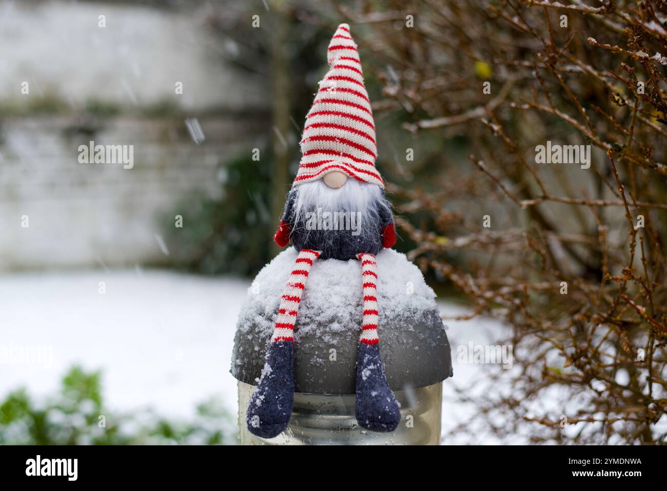Un joli gnome de Noël assis sur une lumière de jardin dans la neige. copier l'espace. bokeh. paysage enneigé Banque D'Images