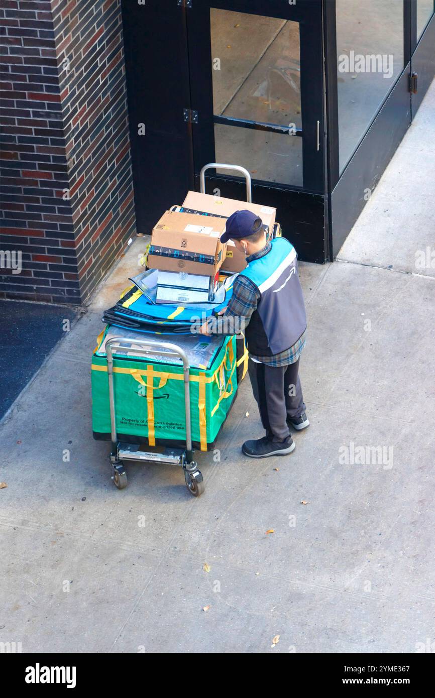 amazon Courier organise les colis de livraison sur le trottoir de la ville de Cart, à côté de l'entrée d'un immeuble de bureaux dans un cadre urbain manhattan New york Banque D'Images
