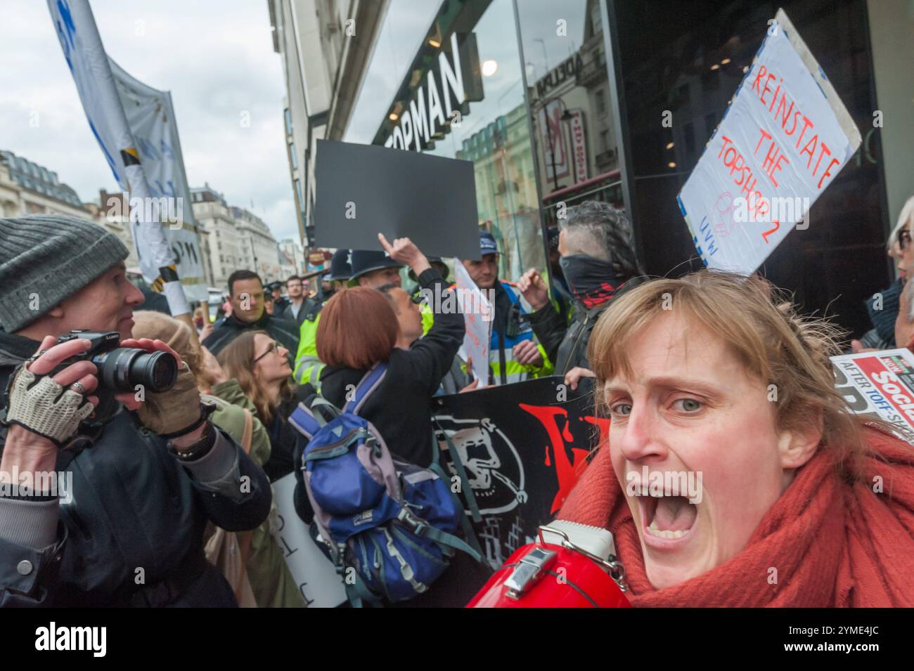 United Voices of the World organise une manifestation à l'extérieur de Topshop sur le Strand, demandant la réintégration de 2 travailleurs suspendus par l'entrepreneur de nettoyage Britannia pour avoir réclamé le salaire de subsistance de 9,40 £ l'heure à Londres pour les nettoyeurs travaillant à Topshop. La trésorière de l'UVW, Vera Weghmann, crie alors que la police photographie et pousse les manifestants. Banque D'Images