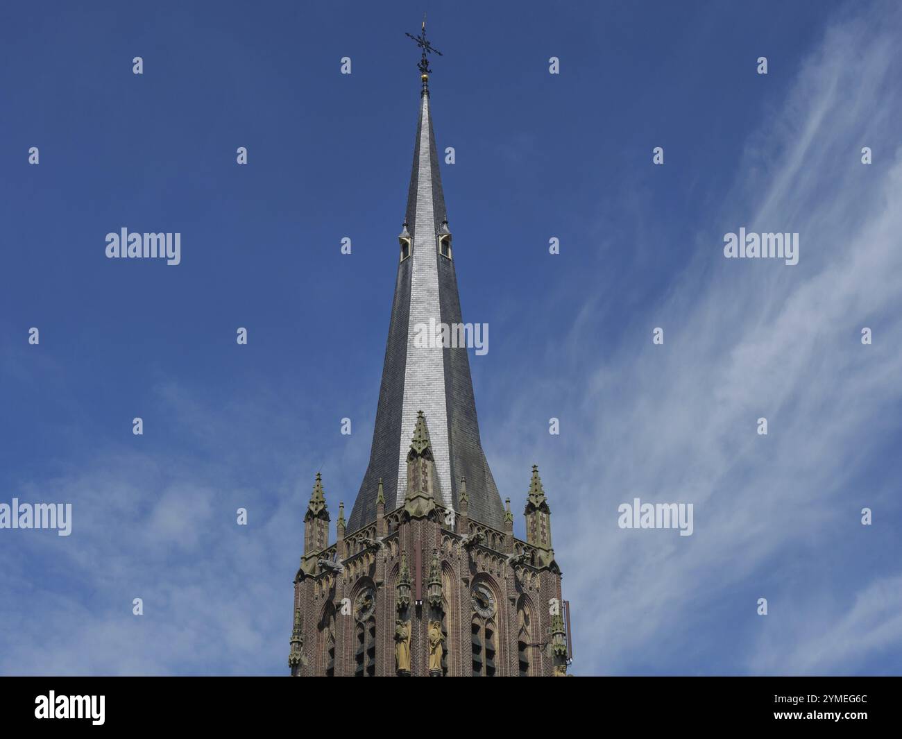 Tour d'église gothique avec une flèche s'élevant contre un ciel bleu clair, lichtenvoorde, gueldre, pays-bas Banque D'Images