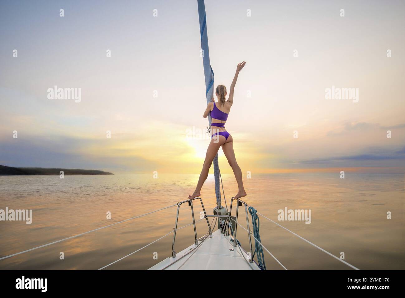 Fille naviguant sur le yacht sur une rencontre du soleil. La fille agite sa main depuis le yacht. Promenade romantique sur le yacht. Voyager sur un yacht Banque D'Images